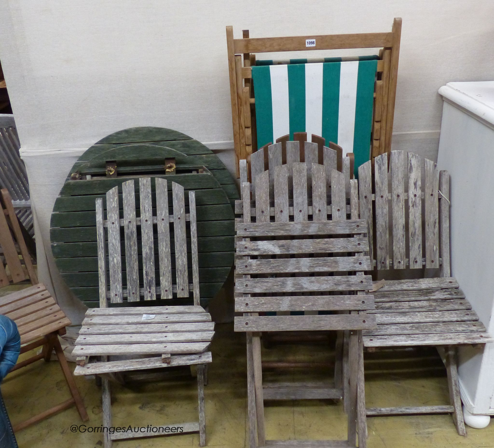 Six assorted weathered teak folding garden chairs, two similar circular tables and a deck chair